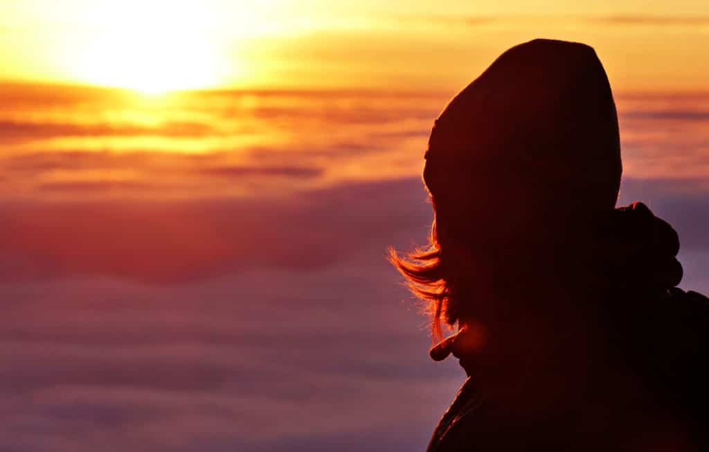 Person beobachtet Sonnenuntergang